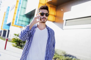 Genç adam konuşmak telefon şehir