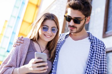 Cep telefonuyla sokakta gençler