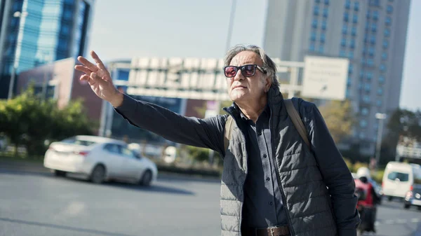 Senior man calls a taxi — Stock Photo, Image