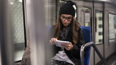 Genç kadın metroda dijital tablet kullanma