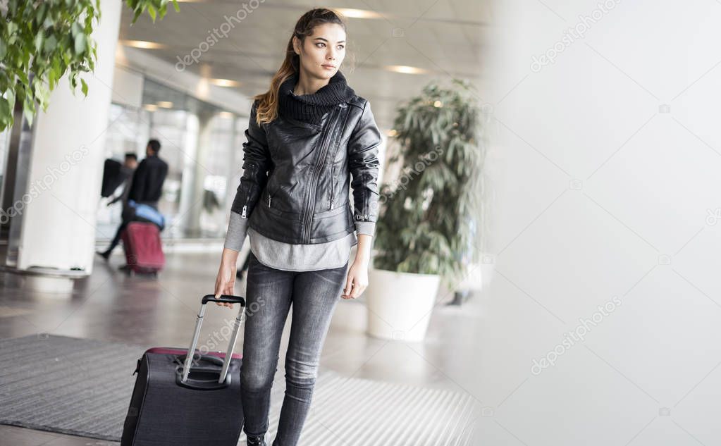 Passenger walking  at the airport with suitcase 