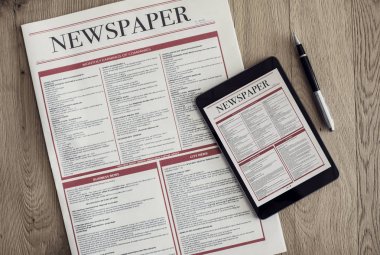 Ahşap arka plan üzerinde dijital tablet ile gazete