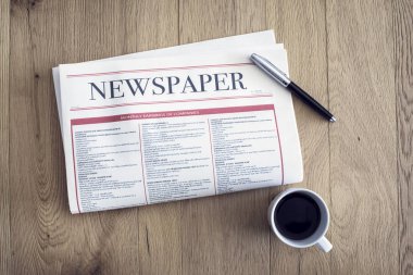 Ahşap arka plan üzerinde kahve içme ve gazete okuma
