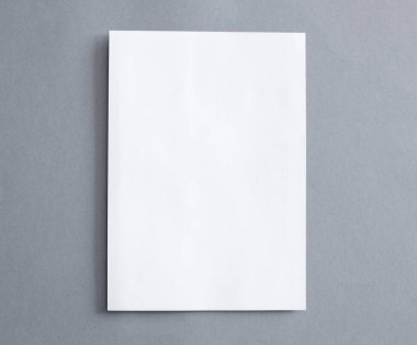 Gri arka plan üzerinde boş beyaz kağıt
