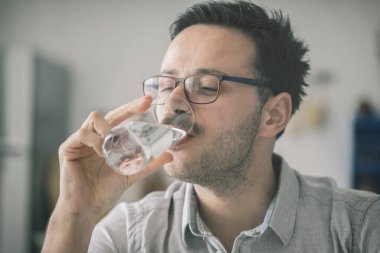 Genç adam bardak su içme