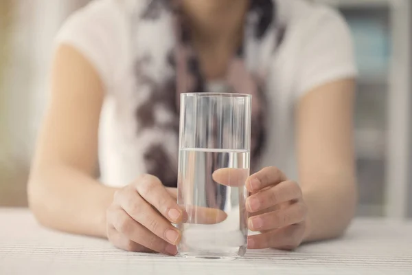 Mujer joven sosteniendo un vaso de agua — Foto de Stock