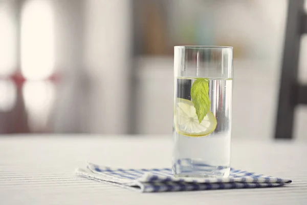 Copo de água com limão e hortelã na cozinha — Fotografia de Stock