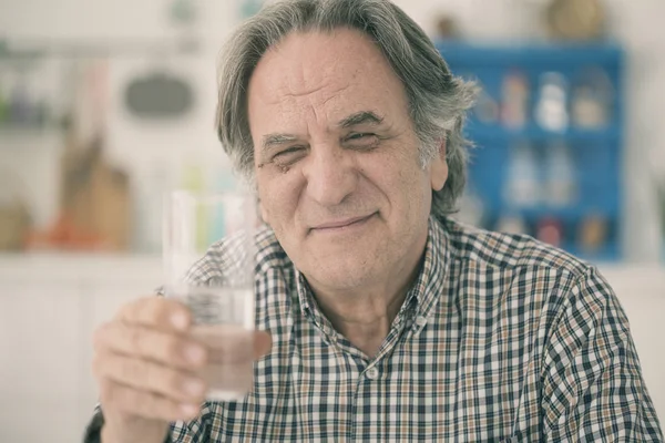 Viejo teniendo vaso de agua en la cocina — Foto de Stock