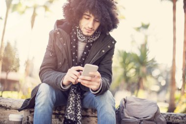 Genç adam cep telefonu kullanıyor.