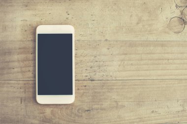 Ahşap arka plan üzerinde beyaz cep telefonu