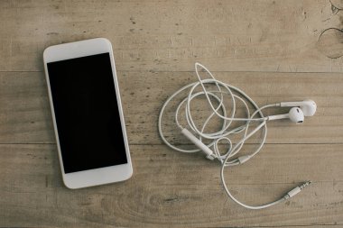 Beyaz cep telefonu kulaklık ahşap arka plan