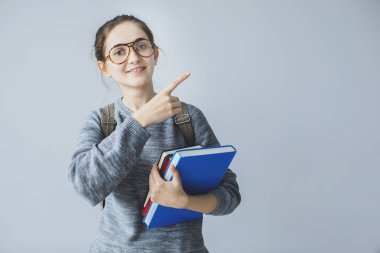 Yukarı doğru onun işaret parmağı ile gösterilen genç kız öğrenci