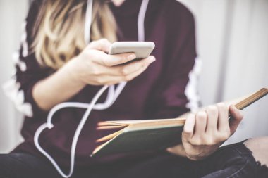 Cep telefonu ve okuma kitabı dışında kullanan genç kız