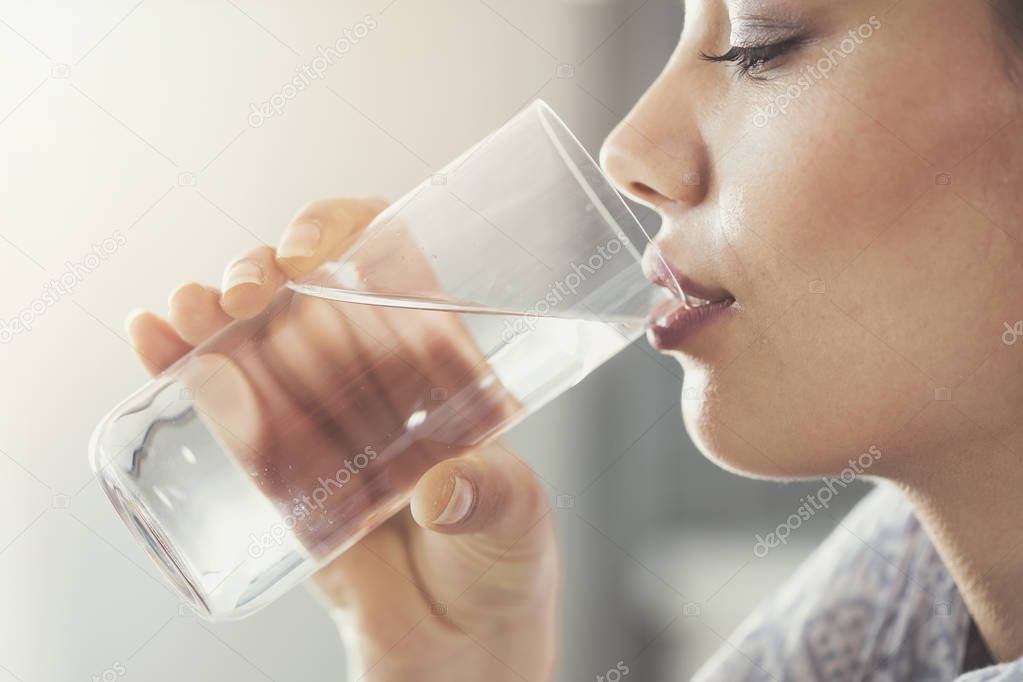 Young woman drinking pure glass of water