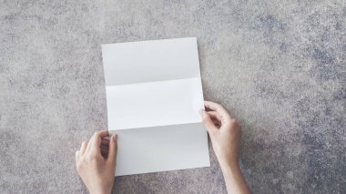 Erkek holding boş beyaz katlanmış kağıt arka plan üzerinde eller