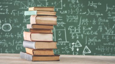 Yeşil tebeşir tahtası önünde kitaplar