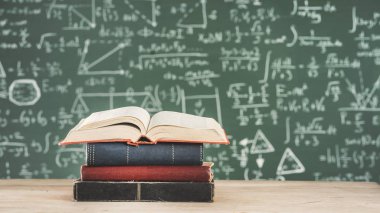 Yeşil tebeşir tahtası önünde kitaplar
