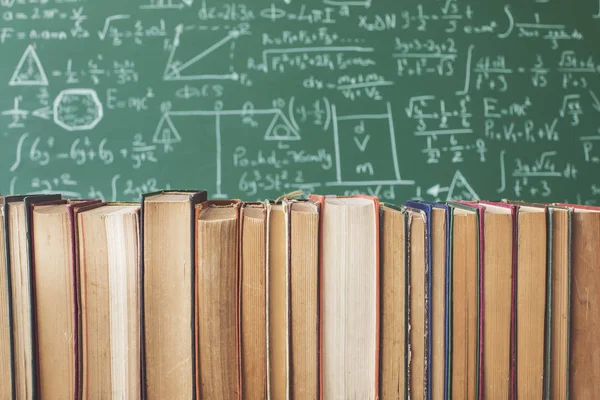 Books in front of green chalk board