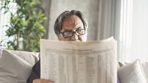 Homem Sênior Lendo Jornal Casa — Fotografia de Stock