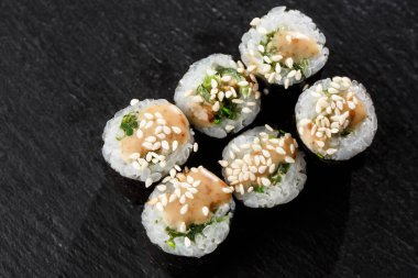 Wakame ve fındık soslu Maki Suşi Rolls. Siyah arka planda. Suşi menüsü. Japon yemeği. Sushi dürümlü lezzetli Japon yemeklerini yakından çek. Yatay fotoğraf
