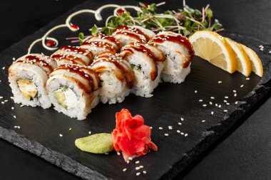 İçinde salatalık, avokado, yılan balığı ve krem peynirli suşi ruloları var. Philadelphia unagi karidesli suşi. Suşi menüsü. Yatay fotoğraf.