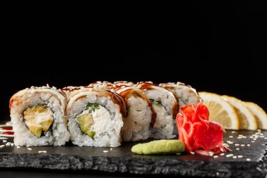 İçinde salatalık, avokado, yılan balığı ve krem peynirli suşi ruloları var. Philadelphia unagi karidesli suşi. Suşi menüsü. Yatay fotoğraf.