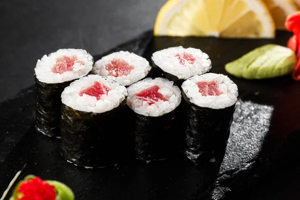 Siyah arka planda ton balıklı Maki suşi ruloları. Suşi menüsü. Japon yemeği. Sushi dürümlü lezzetli Japon yemeklerini yakından çek. Yatay fotoğraf