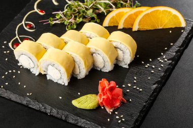 İçinde işlenmiş peynirli suşi ruloları, çedar peyniri, Amerikan peyniri ve krem peynir var. Philadelphia usulü suşi ve karides. Suşi menüsü. Yatay fotoğraf.