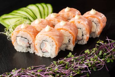 İçinde alevli somon, karides, yengeç eti ve krem peynirli suşi ruloları var. Philadelphia usulü suşi ve karides. Suşi menüsü. Yatay fotoğraf.