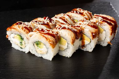 İçinde salatalık, avokado, yılan balığı, omlet ve krem peynirli suşi ruloları var. Philadelphia unagi suşisi ve tamago. Suşi menüsü. Yatay fotoğraf.