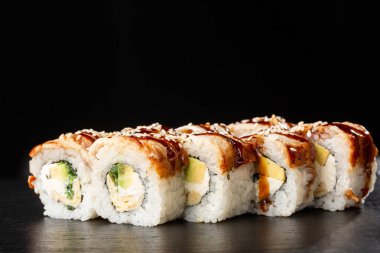 İçinde salatalık, avokado, yılan balığı, omlet ve krem peynirli suşi ruloları var. Philadelphia unagi suşisi ve tamago. Suşi menüsü. Yatay fotoğraf.