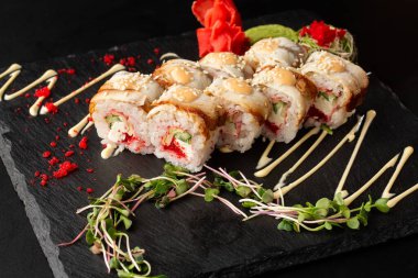 İçinde salatalık, uçan balık havyarı, yılan balığı, omlet ve krem peynirli suşi ruloları var. Philadelphia unagi suşisi ve tamago. Suşi menüsü. Yatay fotoğraf.