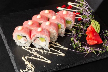 İçinde avokado, ton balığı, karides, yengeç eti ve krem peynirli suşi ruloları var. Philadelphia suşisi ve ton balığı. Suşi menüsü. Yatay fotoğraf.