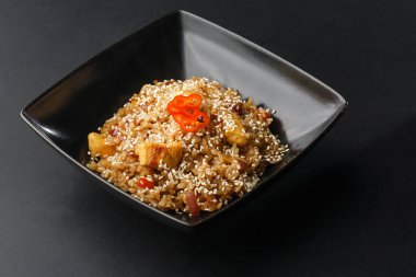 Yumurtalı Asya pilavı, ananas ve yakın plan bir tabakta susam, yukarıdan yatay görüş. Nijerya yemek partisi: Bir tabakta yakın plan kızarmış tavuklu Jollof pilav.