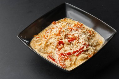  Siyah arka planda siyah bir kasede lezzetli kremalı peynir soslu sebze ve udon eriştesi. Yatay fotoğraf.
