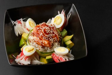 Lezzetli tavuk pilavı. Asya usulü Hainan usulü tavuklu pilav. Asya yemekleri. Tso 'nun tavuğu, pilav, avokado, yengeç eti ve siyah arka planda yumurta. Yukarıdan yatay görünüm