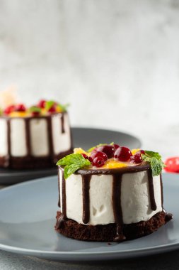 Meyveli mini yuvarlak sufle keki ve mermer arka planda çikolatalı jöle. Pasta kafesi ya da kafe menüsü için duvar kağıdı. dikey.