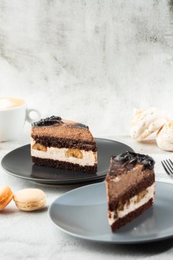 Muzlu çikolatalı kek, gri tabakta mermer arka planda. Seçici odaklanma. Dikey fotoğraf. Fırın için menü. Kafe menüsü. Hamur işi. Cafe restoranında lezzetli ve tatlı bir tatlı..