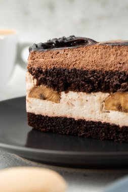 Muzlu çikolatalı kek, gri tabakta mermer arka planda. Seçici odaklanma. Dikey fotoğraf. Fırın için menü. Kafe menüsü. Hamur işi. Cafe restoranında lezzetli ve tatlı bir tatlı..