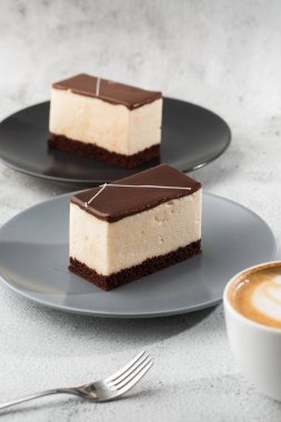 Sufle kuşu sütü, bisküvi, krema ve siyah bir tabakta siyah çikolata, beyaz sufle keki. Fırın için menü. Kafe menüsü. Kafe restoranında lezzetli ve tatlı bir tatlı.
