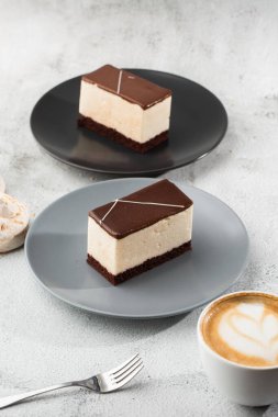 Sufle kuşu sütü, bisküvi, krema ve siyah bir tabakta siyah çikolata, beyaz sufle keki. Fırın için menü. Kafe menüsü. Kafe restoranında lezzetli ve tatlı bir tatlı.
