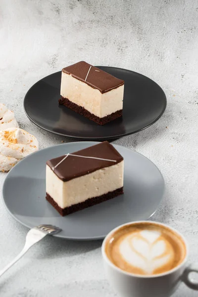 Pedaço de bolo com souffle Leite de pássaro, biscoito, mousse e chocolate escuro em um prato escuro, bolo de souffle branco. Menu para padaria. Menu de café. Deliciosa e doce sobremesa no restaurante café.Vertical — Fotografia de Stock