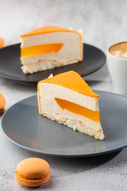 Hindistan cevizli, çarkıfelek meyveli, mangolu ve muzlu, çikolata jöleli zarif kek. Mermer zemin üzerinde turuncu katmanlı kek dilimi. Pasta kafesi ya da kafe menüsü için duvar kağıdı. dikey.