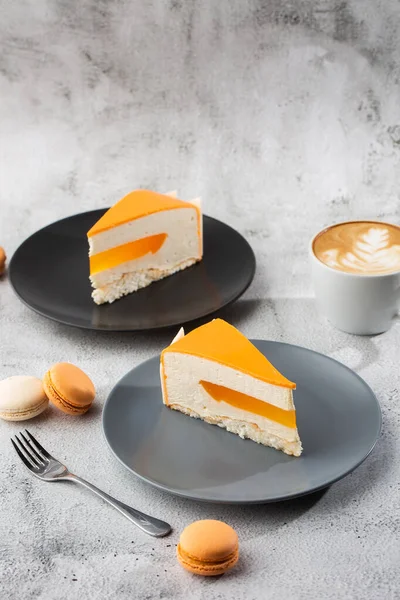 Hindistan cevizli, çarkıfelek meyveli, mangolu ve muzlu, çikolata jöleli zarif kek. Mermer zemin üzerinde turuncu katmanlı kek dilimi. Pasta kafesi ya da kafe menüsü için duvar kağıdı. dikey.