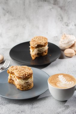 Muz ya da mermer arka planda gri tabakta fındıklı kek. Seçici odaklanma. Dikey fotoğraf. Fırın için menü. Kafe menüsü. Hamur işi. Cafe restoranında lezzetli ve tatlı bir tatlı..