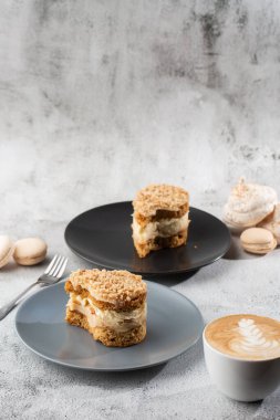 Muz ya da mermer arka planda gri tabakta fındıklı kek. Seçici odaklanma. Dikey fotoğraf. Fırın için menü. Kafe menüsü. Hamur işi. Cafe restoranında lezzetli ve tatlı bir tatlı..