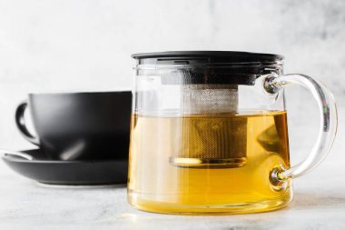 Koyu yeşil, papatya çayı, papatya çayı ya da parlak mermer arka planda izole edilmiş sarı çay. Genel görünüm, kopyalama alanı. Kafe menüsü reklamı. Kahve dükkanı menüsü. Yatay fotoğraf.