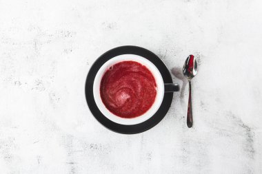 Parlak mermer arka planda koyu fincanda yaban mersini, kırmızı ya da ahududu çayı. Genel görünüm, kopyalama alanı. Kafe menüsü reklamı. Kahve dükkanı menüsü. Yatay fotoğraf.