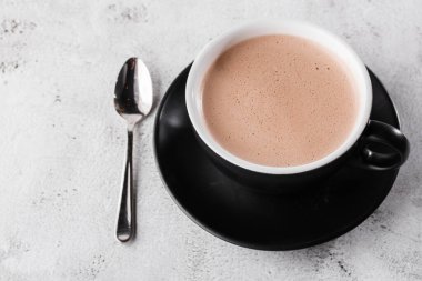 Bir fincan sıcak kakao ya da parlak mermer arka planda izole edilmiş koyu bardakta sıcak çikolata. Genel görünüm, kopyalama alanı. Kafe menüsü reklamı. Kahve dükkanı menüsü. Yatay fotoğraf. Geleneksel kazanç içecekleri