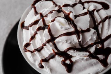 Krem şanti ve çikolata soslu kahve. Karanlık bardakta buzlu frappuccino parlak mermer arka planda izole edilmiş. Genel görünüm, kopyalama alanı. Kafe menüsü reklamı. Kahve dükkanı menüsü. Yatay ph